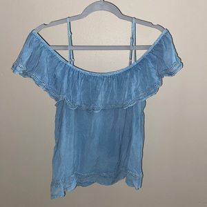 Off the shoulder, denim blue shirt.